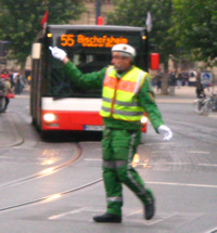 Polizeibeamter regelt den Straenverkehr vor einem stdtischen Bus